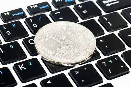 Back side of a silver coin bitcoin on a close-up keyboardの写真素材