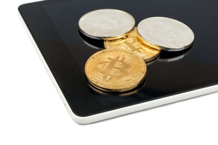 Silver and gold coins of bitcoin on the tablet closeupの写真素材