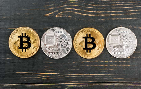Gold and silver bitcoin coins on wooden background, top viewの写真素材