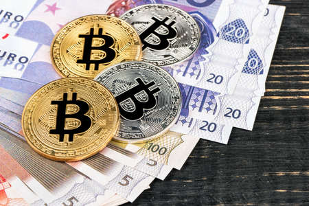 Gold and silver bitcoin coins with Euro on the table