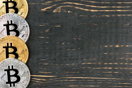 Silver and gold coins bitcoin on an empty wooden backgroundの写真素材