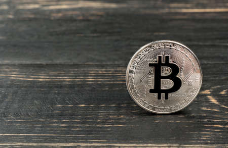Silver coin bitcoin on an empty wooden backgroundの写真素材