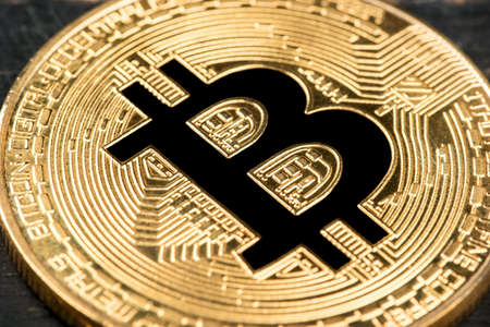 Symbol of bitcoin on a gold coin close up