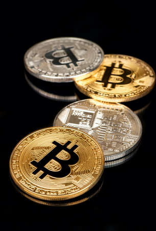 Scattered gold and silver bitcoin coins on black backgroundの写真素材