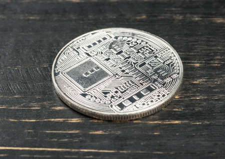 Back side of the silver coin bitcoin on wooden backgroundの写真素材