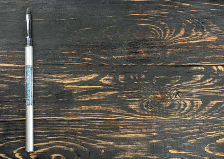 Brush for nail extensions on an empty wooden backgroundの写真素材