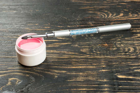 Brush for nail extension with pink gel on the tableの写真素材
