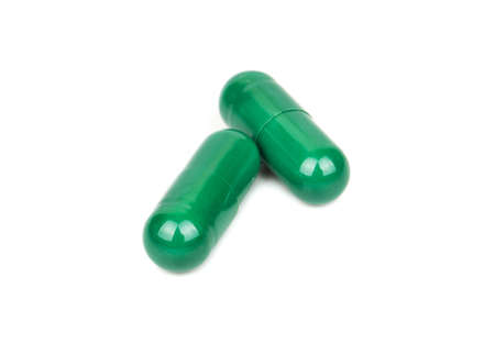 Two green herbal capsule isolated on white backgroundの写真素材