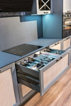 Open drawer with cutlery in the kitchen close-upの写真素材