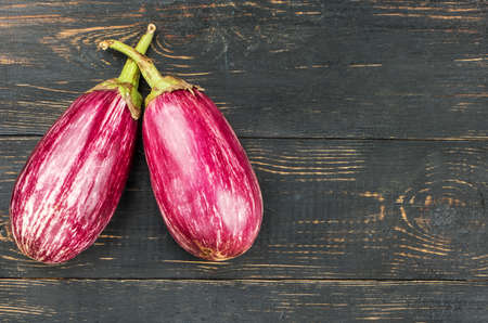 Two fresh purple eggplant empty wooden background