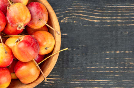 Part of bowl with paradise apples on wooden backgroundの写真素材