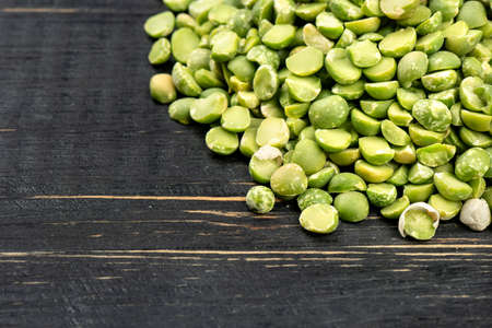 Scattered dry green peas on wooden background, close-upの写真素材