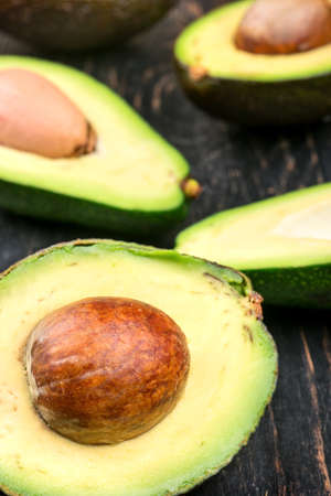 Scatter half of avocado on wooden background