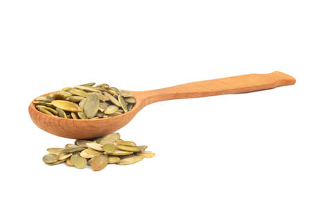 Pumpkin seed kernels in wooden spoon on white backgroundの写真素材