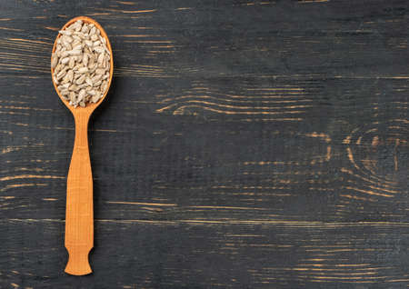 Sunflower seeds without shell in a spoon on an empty wooden backgroundの写真素材