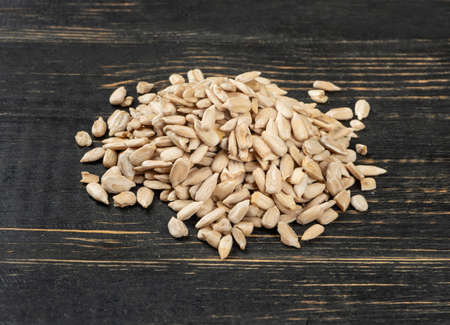 Bunch of sunflower seeds without a shell on a wooden background close-upの写真素材