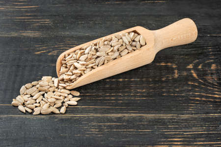 Sunflower seeds without shell in a scoop on a dark tableの写真素材
