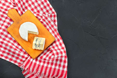 Brie cheese with slice on cutting board and towelm top viewの写真素材