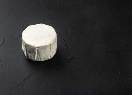 Round brie cheese with mold on dark concrete backgroundの写真素材