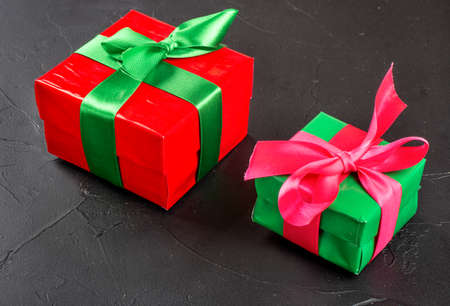 Red and green box with gifts on concrete background
