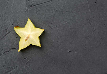 Juicy slice of carambola fruit on an empty concrete backgroundの写真素材