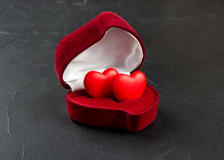 Ring box with hearts inside on dark backgroundの写真素材