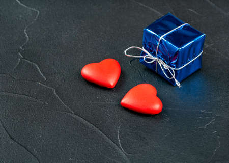 Two hearts with a gift on a dark backgroundの写真素材