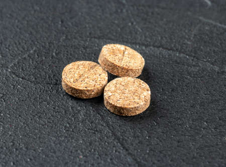 Three herbal pills on a dark concrete background close-upの写真素材