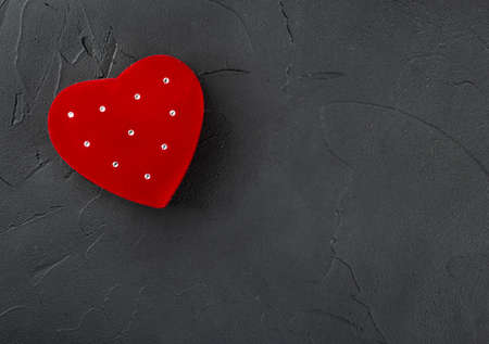 Red box for rings in the shape of a heart on a concrete background, top viewの写真素材