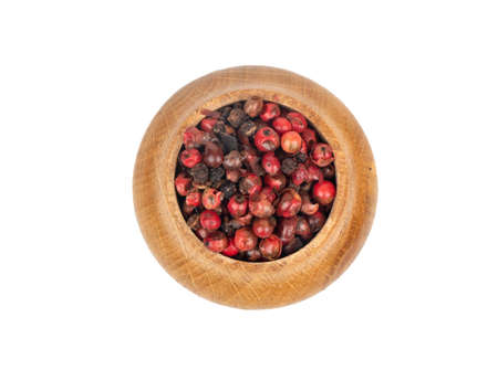 Small wooden bowl with red pepper peas on white background, top viewの写真素材