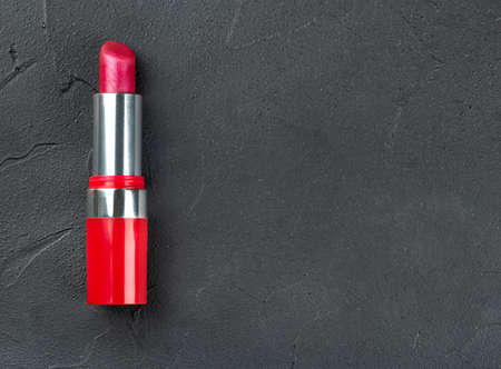 Red lipstick closeup on empty dark concrete backgroundの写真素材