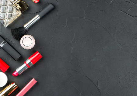 Scattered tube of lipstick on an empty dark background, top viewの写真素材