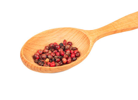 Wooden spoon with red pepper peas close up on white backgroundの写真素材