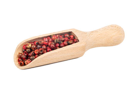 Red pepper in a wooden scoop on white background