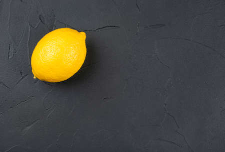 Fresh lemon fruit on dark concrete background, top viewの写真素材