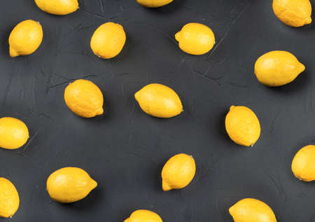 Fresh fruit lemons scattered on a dark concrete background, top viewの写真素材