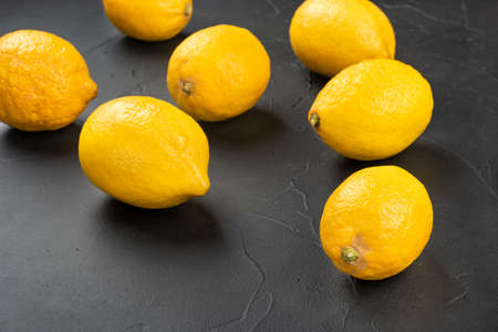 Fresh fruit lemons scattered on a dark concrete backgroundの写真素材