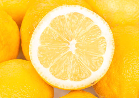 Juicy half on the pile of fruit lemon close-upの写真素材