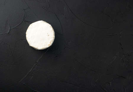 Round brie cheese with mold on dark concrete background, top viewの写真素材