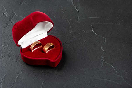 Open box with two wedding rings on concrete background