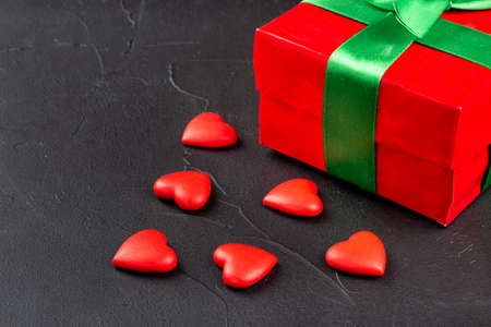Red box with plastic hearts on dark background closeupの写真素材