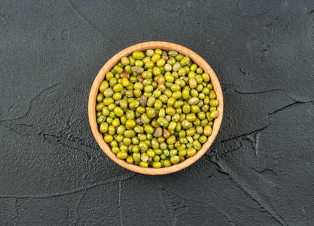 Green mung bean in wooden bowl on concrete background, top viewの写真素材