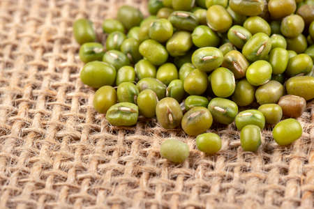Raw green machine grains scattered on burlap closeupの写真素材