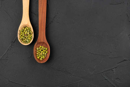 Two spoons with green mung beans on concrete background, top viewの写真素材