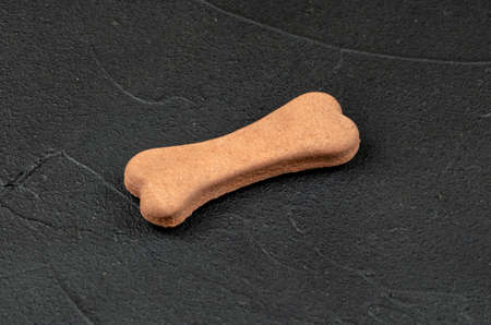 Dog biscuits in the shape of a bone on a concrete backgroundの写真素材
