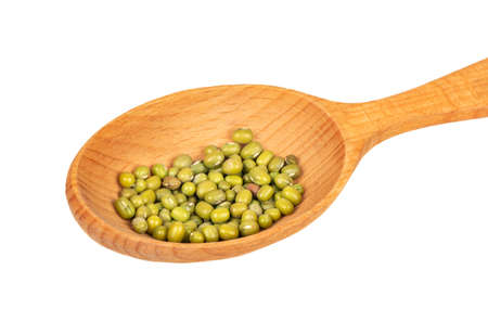 Several green mung beans in a large wooden spoon on a white background closeupの写真素材