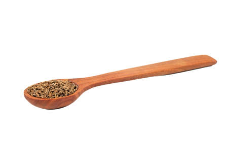 Spice dry cumin in wooden spoon isolated on white backgroundの写真素材