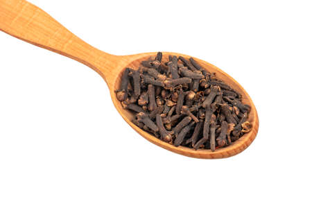 Wooden spoon with dry spice cloves on white background closeupの写真素材