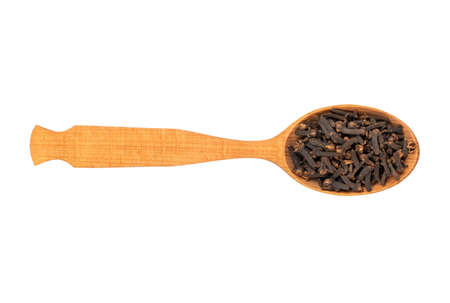 Wooden spoon with dry spice cloves on white background, top viewの写真素材
