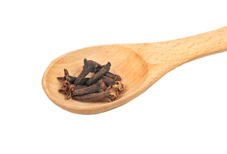 Wooden spoon with dry cloves isolated on white background closeupの写真素材